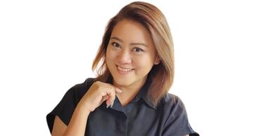 Smiling woman in a black shirt against a white background.