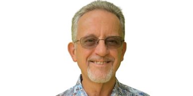 Smiling elderly man with glasses against a white background.