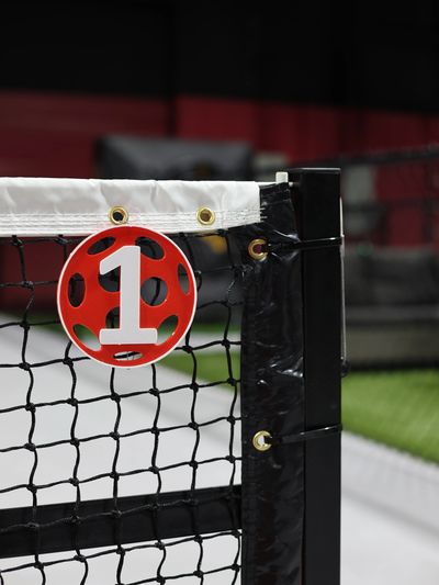 Tennis net with a red and white number 1 marker attached.