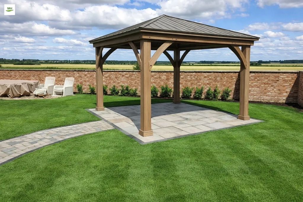 Wooden gazebo with metal roof in a green backyard beside a brick wall.