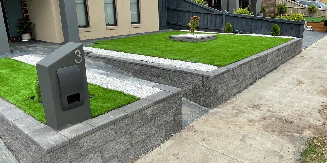 Modern front yard with neatly trimmed grass and stone accents.