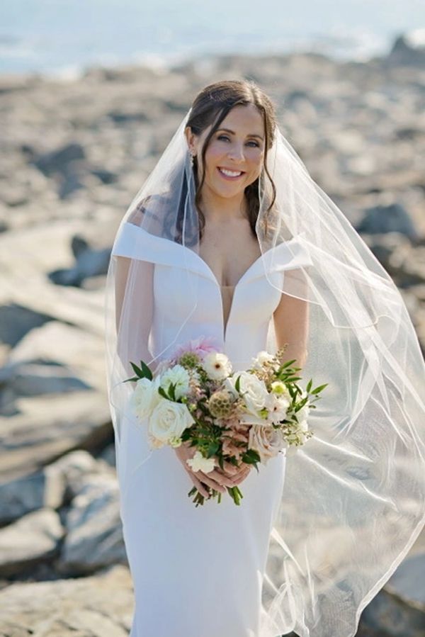 Woman brides posing in wedding dresses with white flowers