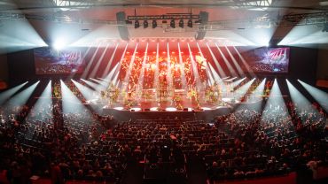 Concert stage with vibrant lighting and a large audience.