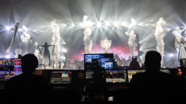 Tech crew managing lights and effects at a concert.