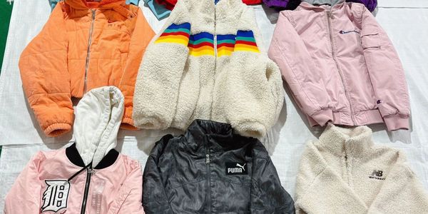 Six colorful jackets laid out on a white surface.