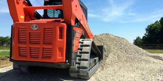 Compact Track Loader, skid steer spreading gravel in Whitesboro, Texas.