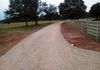 Drainage grading and a new topping of crushed rock for this gravel driveway in Alvord, Texas.