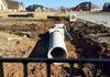 Installing sections of concrete culvert pipe (RCP) for a driveway entrance in Justin, Texas.