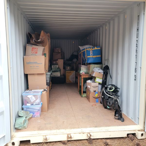 Storage container filled with boxes, bags, and miscellaneous items.