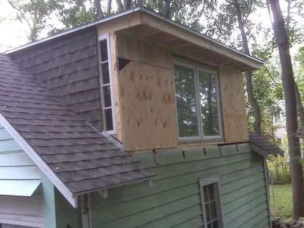House under renovation with new window installation on the upper floor.
