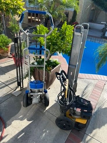 Two pieces of outdoor equipment on a patio near a pool.