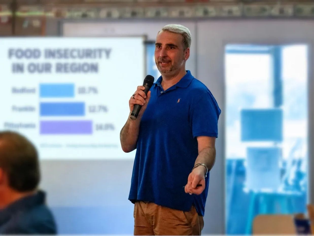 Joey Donovant speaking about food insecurity with a microphone.
