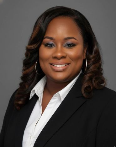 Professional headshot of a smiling woman in business attire.