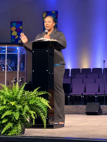 Woman speaking at a podium in a church.