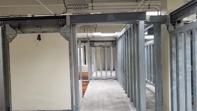 Empty indoor shooting range lane marked with number 4 and metal dividers.