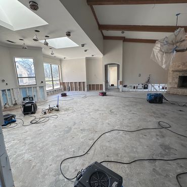 Large room under renovation with exposed walls and construction equipment.