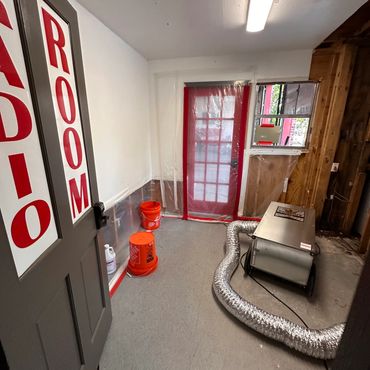 An audio room under renovation with equipment and protective plastic sheeting.