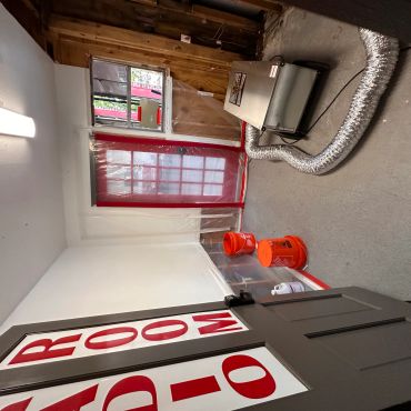 An audio room under renovation with equipment and protective plastic sheeting.