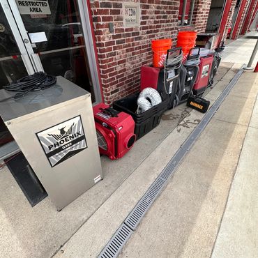 Industrial equipment lined up outside a brick building on a sunny day.