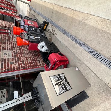 Industrial equipment lined up outside a brick building on a sunny day.