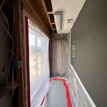 Room covered in plastic sheeting with taped seams.