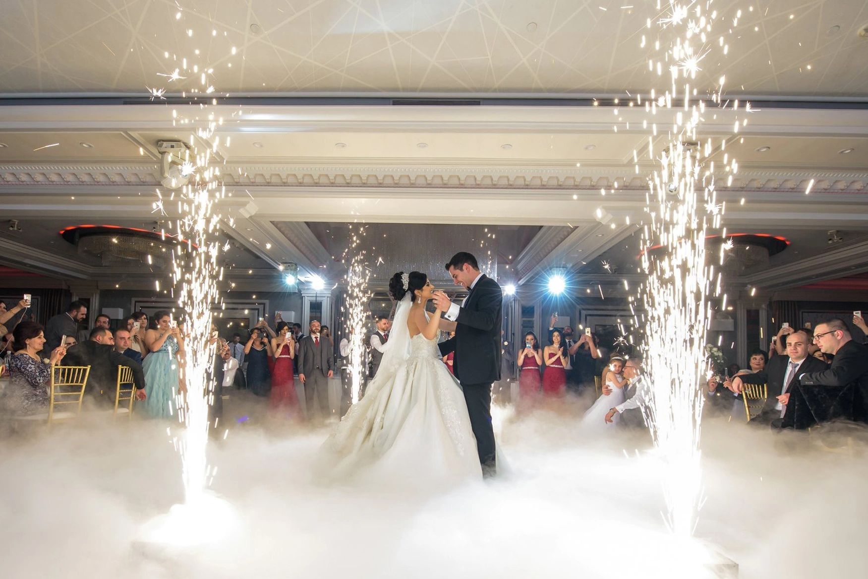 Bride and groom share a magical first dance surrounded by sparklers and fog.