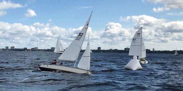 Two sail boats racing around a sail mark