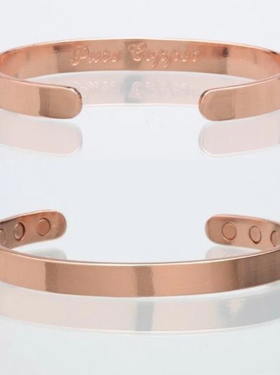 Rose gold open cuff bracelet with magnetic accents.