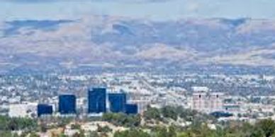 Cityscape with mountains in the background under a clear sky.