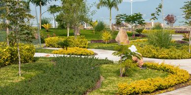 A well-maintained park with lush greenery and paved walkways.