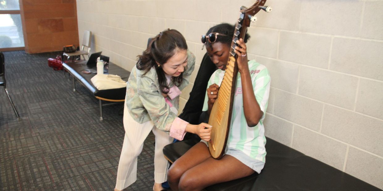 Our Pipa player from the Nanjing Quartet shows an audience member how the Pipa plays, and sound in o