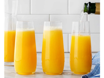 Mimosa drinks being poured in glasses.