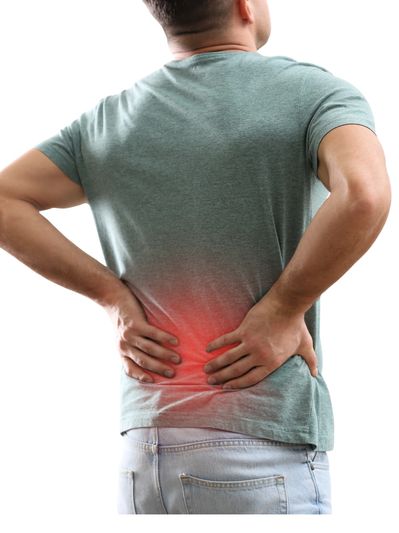 Man holding lower back in pain, indicating discomfort or injury.