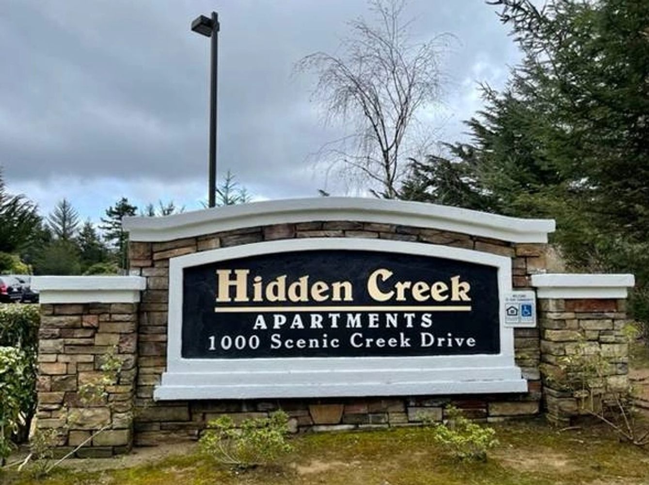 a sign reading Hidden Creek apartments 1000 scenic creek drive