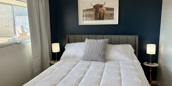 Queen bed in modern Unity SK motel room at REMO Stays