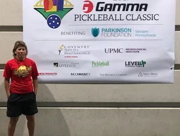 A person stands in front of a banner for the Gamma Pickleball Classic event.