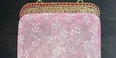 Vintage pink purse with intricate floral design and gold clasp.