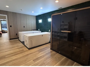 Modern spa room with bathtubs and sauna.