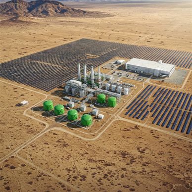A solar power plant with green storage tanks in a desert setting.