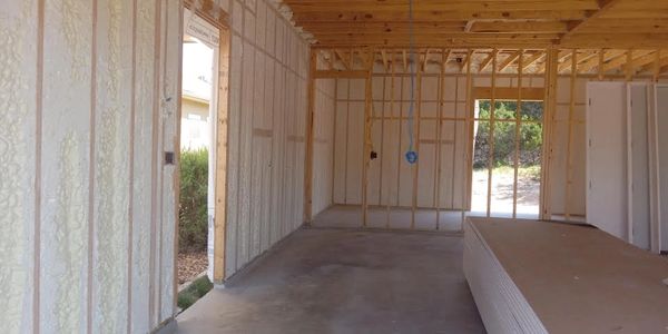 Interior of a building under construction with foam insulation and drywall.