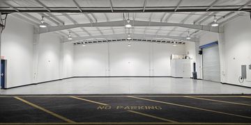 Empty, well-lit indoor parking garage with 'No Parking' zone visible.