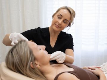 Nurse Cass is measuring the face of a client while preparing for treatment in clinic in Maitland