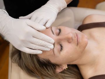 A client lays with eyes closed while Nurse Cass perfroms a massage during a medi facial 