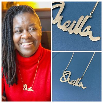 A woman wearing a personalized name necklace smiling 