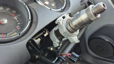 Exposed steering column with removed steering wheel in a car.