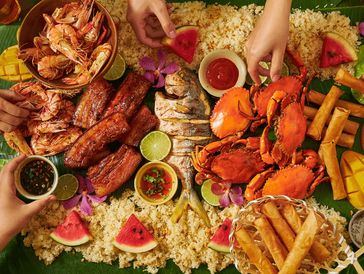 Traditional Filipino Boodle Fight - shared seafood feast served with rice on a banana leaf 