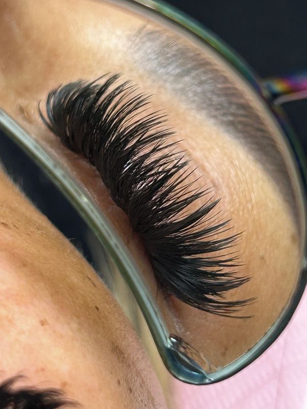 Close-up of thick, curled eyelashes on a closed eye.