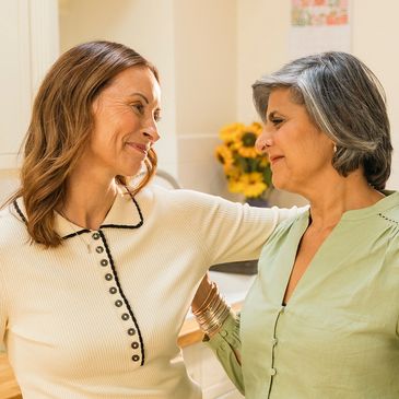 Two women sharing a warm, heartfelt moment indoors.