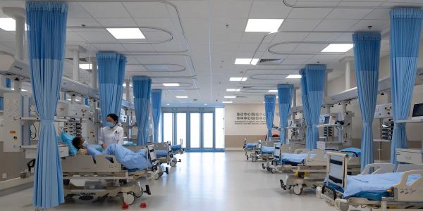 Hospital ward with patients and medical staff.