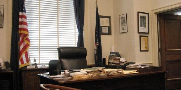 An empty office with a desk and flags.